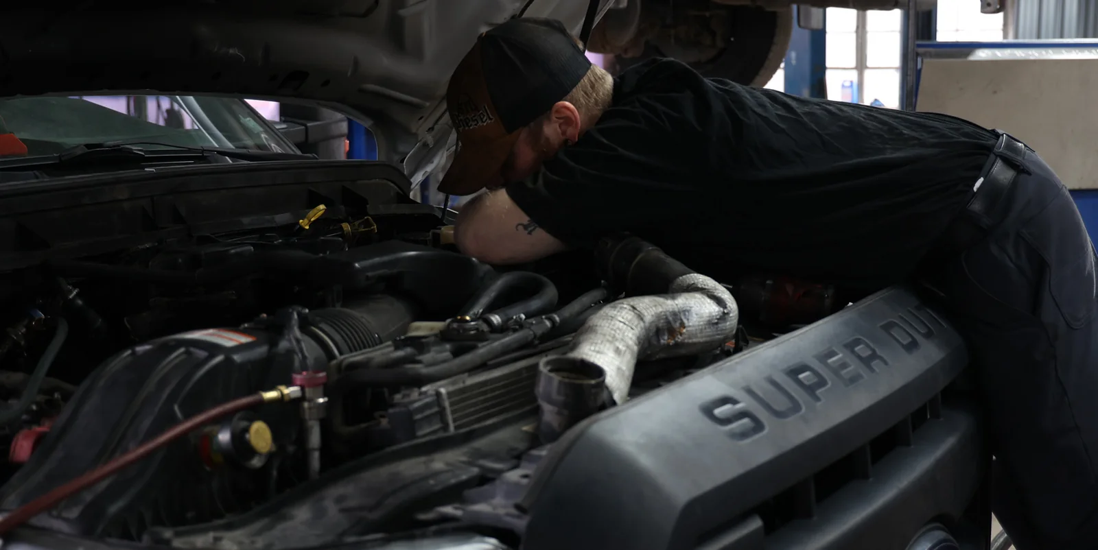 STL Diesel technician working under the hood of a Ford Super Duty